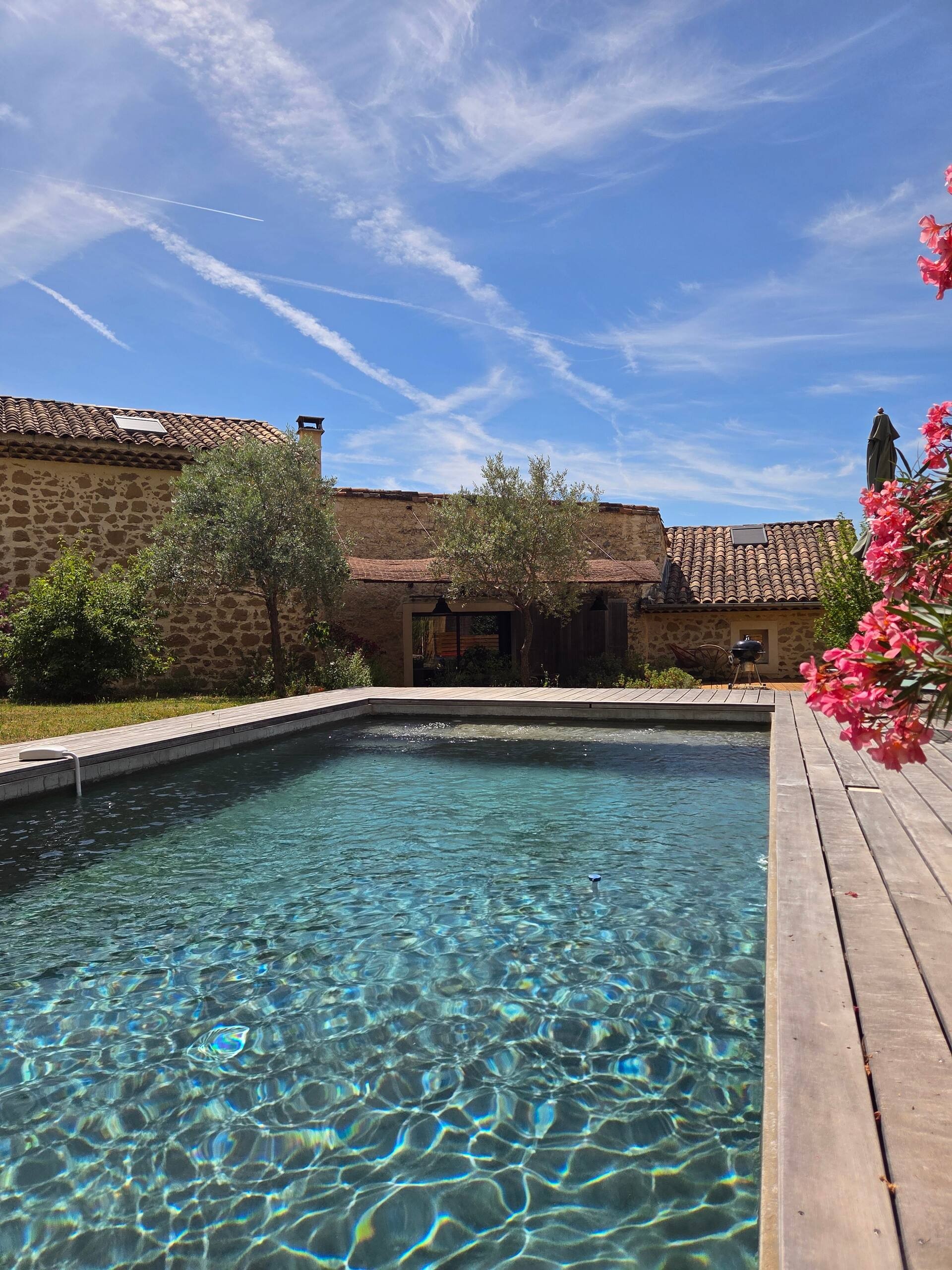La piscine face à la villa en pierre, oliviers et lauriers-roses